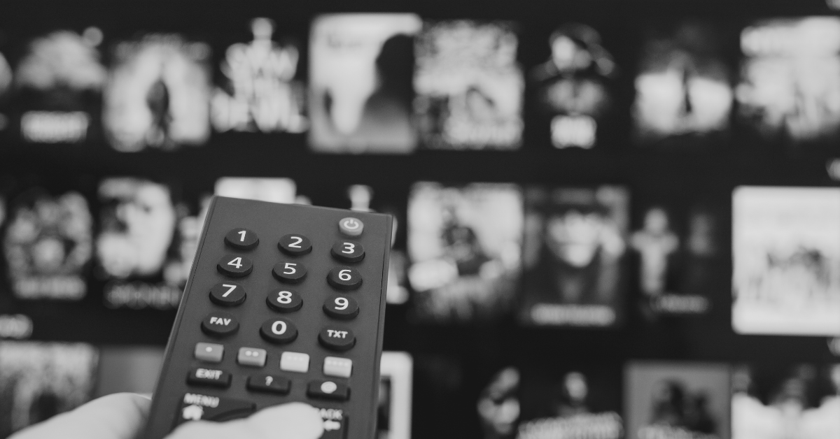 Person pointing remote at TV