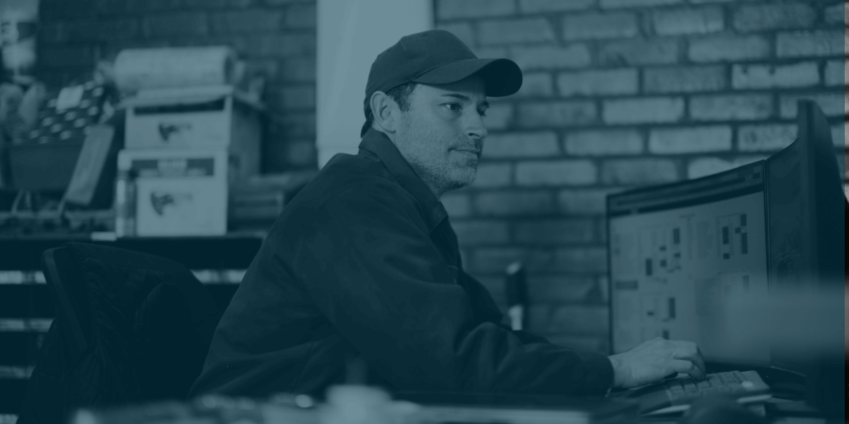 Business professional analyzing market and inventory data on a computer in a modern office environment